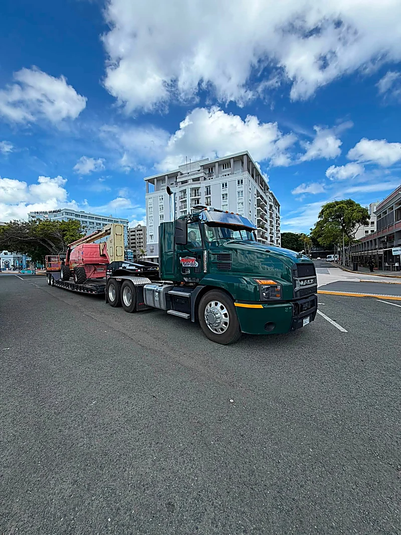 Lowboy transportando un boom lift en el Viejo San Juan